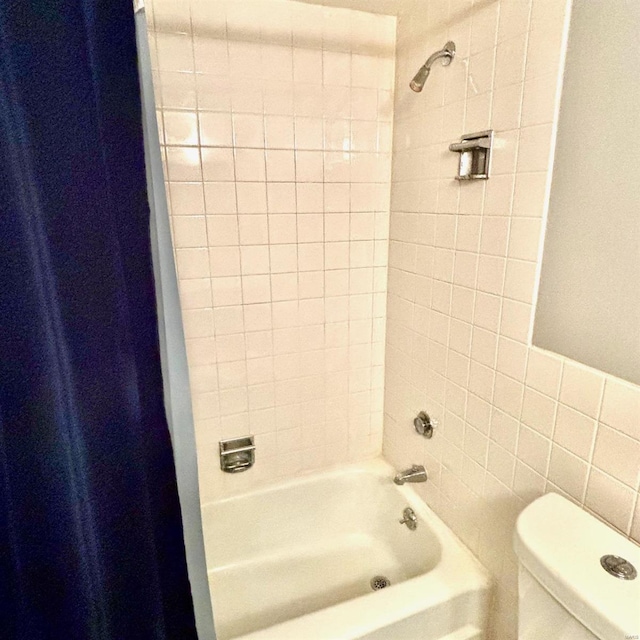 bathroom featuring shower / bath combination with curtain, tile walls, and toilet