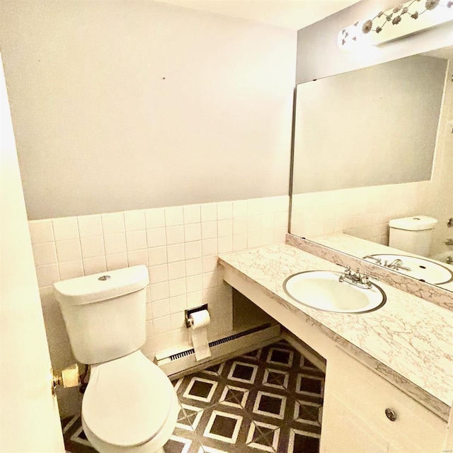 bathroom featuring tile walls, vanity, and toilet