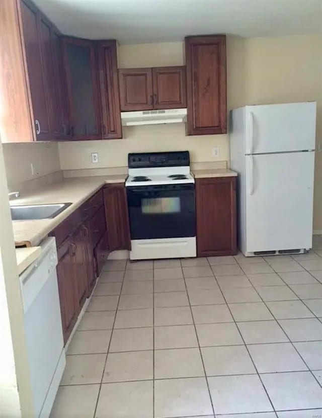 kitchen featuring white appliances, sink, and light tile patterned floors