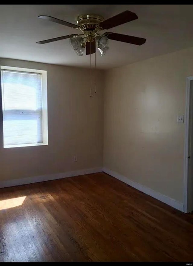 spare room featuring ceiling fan and dark wood-type flooring