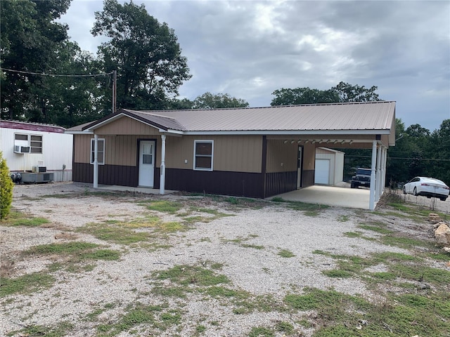 view of front of property with a carport and an outbuilding