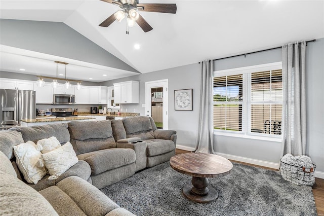 living room featuring vaulted ceiling, ceiling fan, dark wood-type flooring, and sink