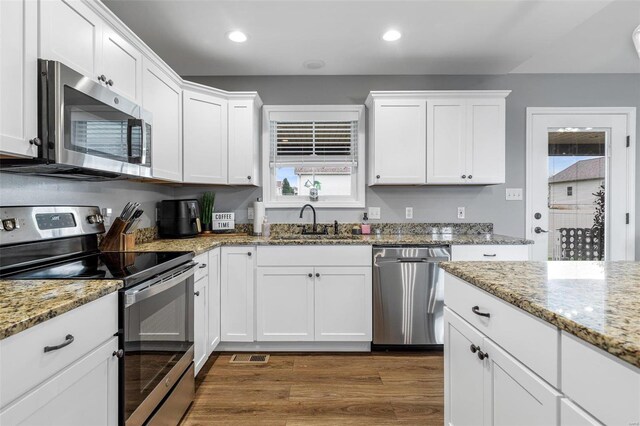 kitchen featuring sink, stainless steel appliances, dark wood-type flooring, and white cabinetry