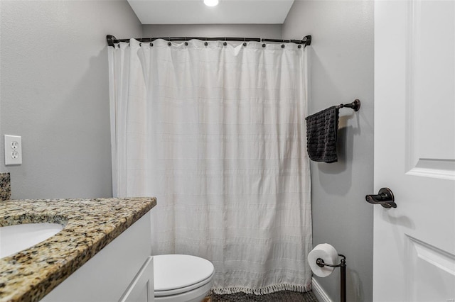 bathroom with walk in shower, vanity, and toilet