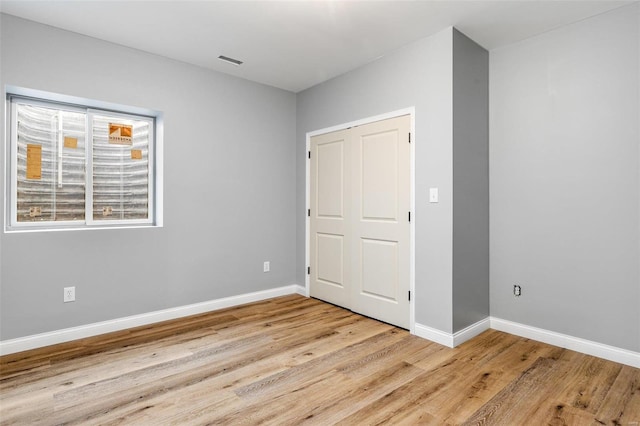 unfurnished bedroom featuring light hardwood / wood-style floors and a closet