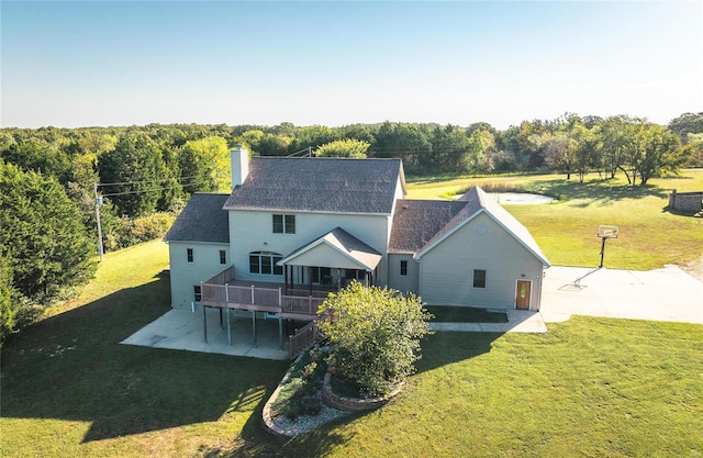 back of house with a wooden deck, a yard, and a patio area