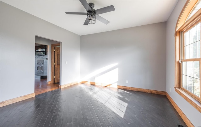 spare room with dark hardwood / wood-style floors and ceiling fan