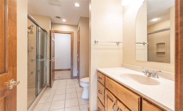 bathroom featuring a shower with shower door, vanity, toilet, and tile patterned floors