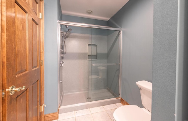 bathroom featuring walk in shower, tile patterned floors, and toilet