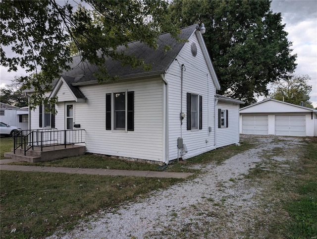 view of front facade with an outbuilding, a garage, and a front lawn