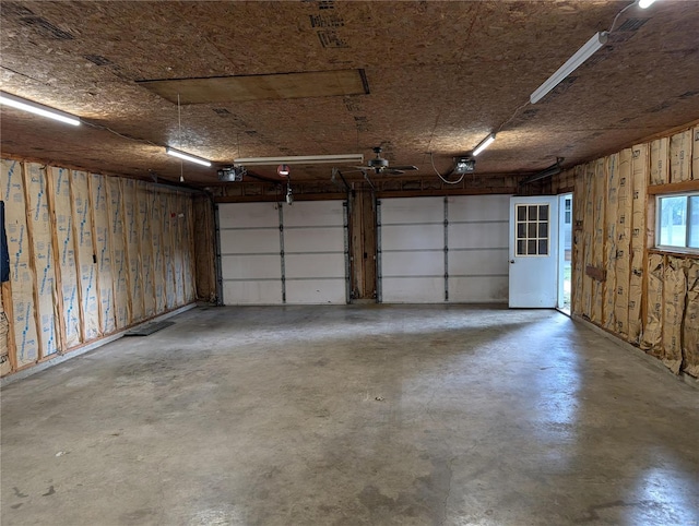 garage with a garage door opener and wood walls