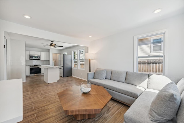 living room with ceiling fan and light wood-type flooring