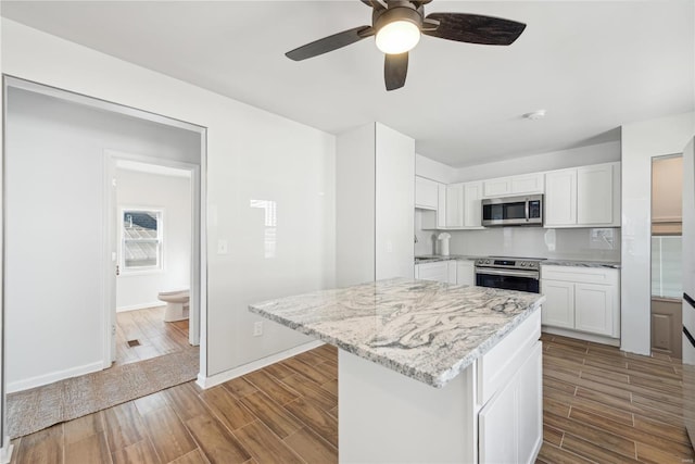 kitchen featuring white cabinetry, light stone countertops, light hardwood / wood-style flooring, and stainless steel appliances