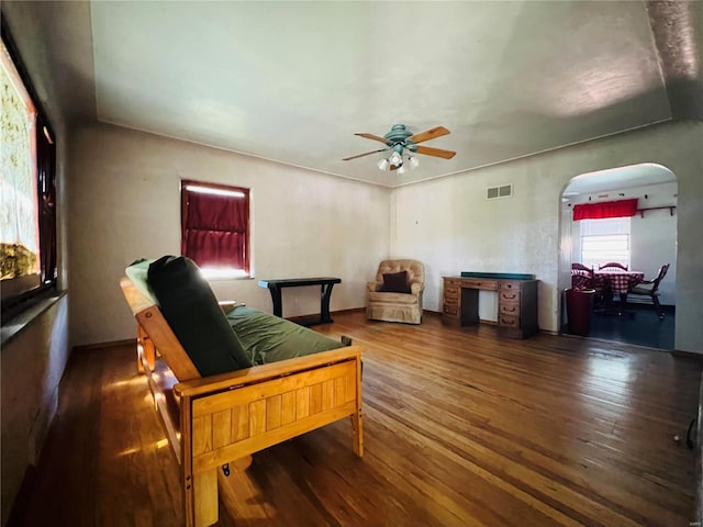 living room featuring ceiling fan and dark hardwood / wood-style flooring