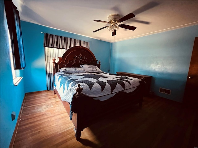 bedroom featuring ornamental molding, ceiling fan, and hardwood / wood-style flooring