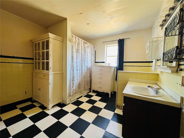 bathroom with walk in shower, tile walls, and vanity