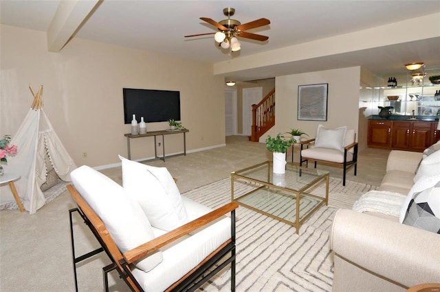 living room featuring ceiling fan, beam ceiling, and light carpet