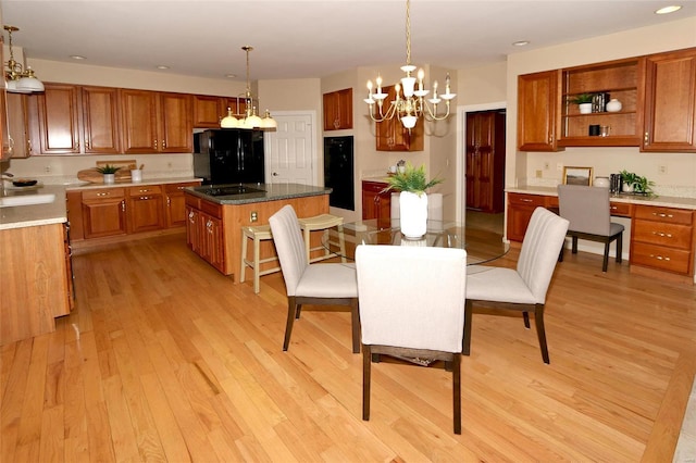 dining room featuring a notable chandelier, built in desk, sink, and light wood-type flooring