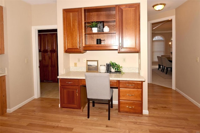 office area with built in desk and light wood-type flooring