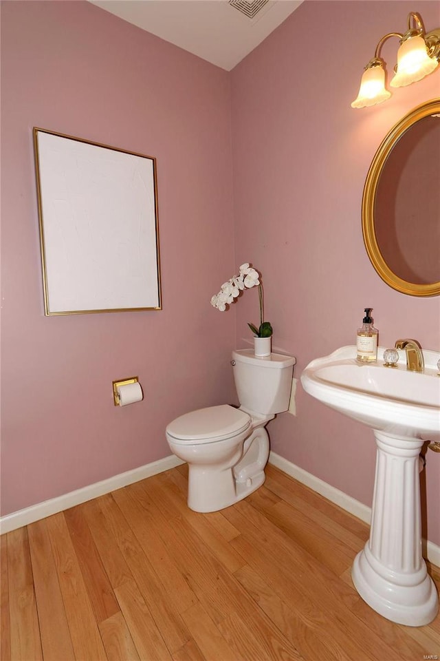 bathroom featuring hardwood / wood-style floors and toilet