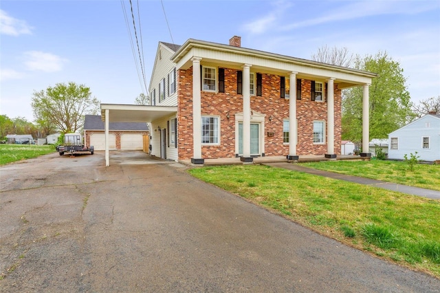 neoclassical home with a front lawn, covered porch, and a garage