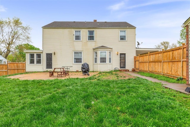 rear view of property featuring a lawn and a patio