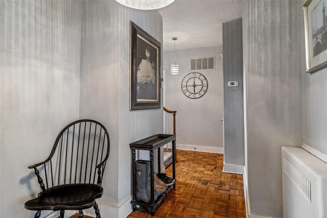 hall with radiator and dark parquet floors