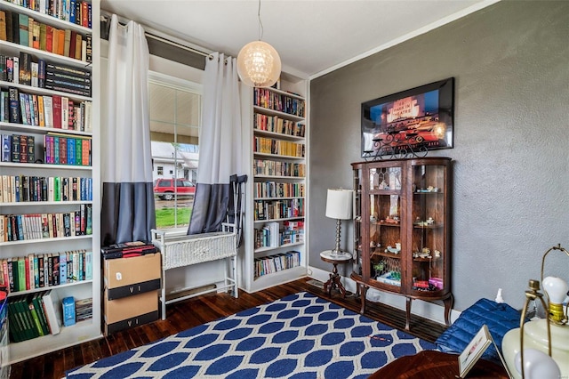 sitting room featuring ornamental molding and dark wood-type flooring