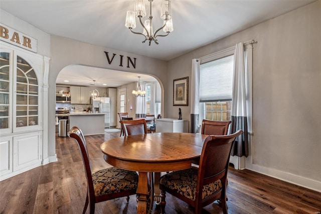 dining area featuring a notable chandelier and dark hardwood / wood-style flooring