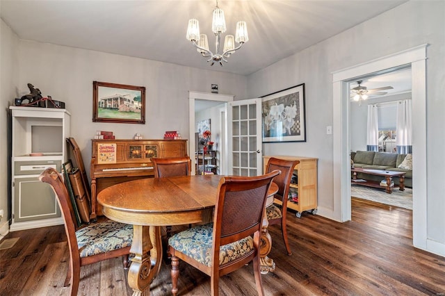 dining room featuring ceiling fan with notable chandelier and dark hardwood / wood-style flooring