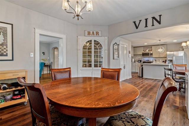 dining space with dark wood-type flooring and a chandelier