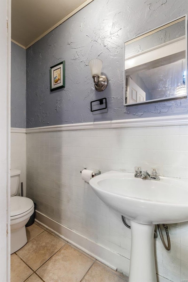 bathroom featuring tile walls, tile patterned floors, and toilet