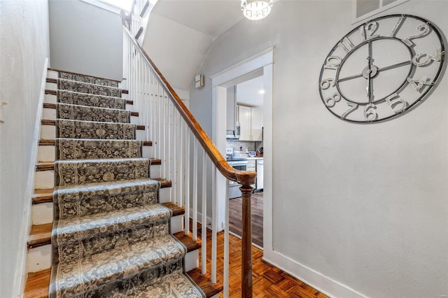 staircase with parquet floors and lofted ceiling