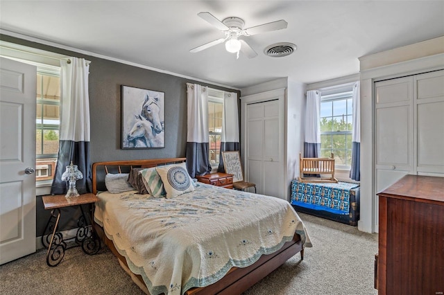 carpeted bedroom with ceiling fan and multiple windows