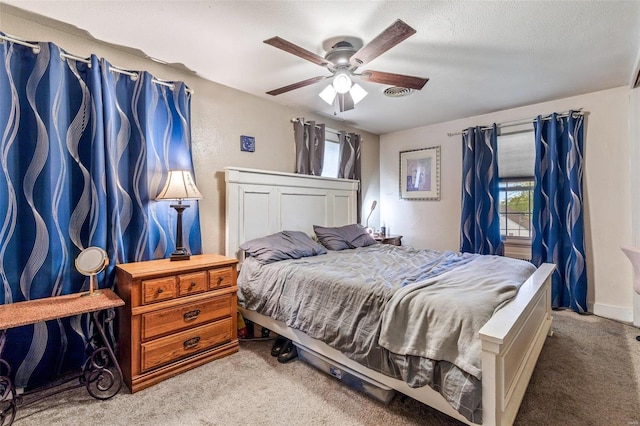 carpeted bedroom featuring multiple windows, a textured ceiling, and ceiling fan