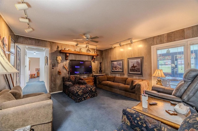 living room with ceiling fan, wooden walls, and track lighting