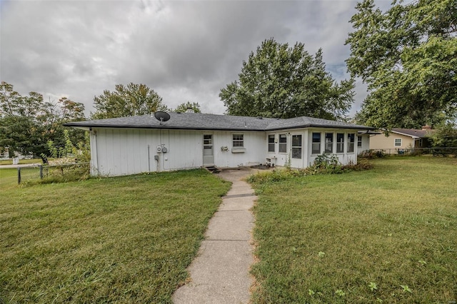 view of front facade featuring a front yard and a sunroom