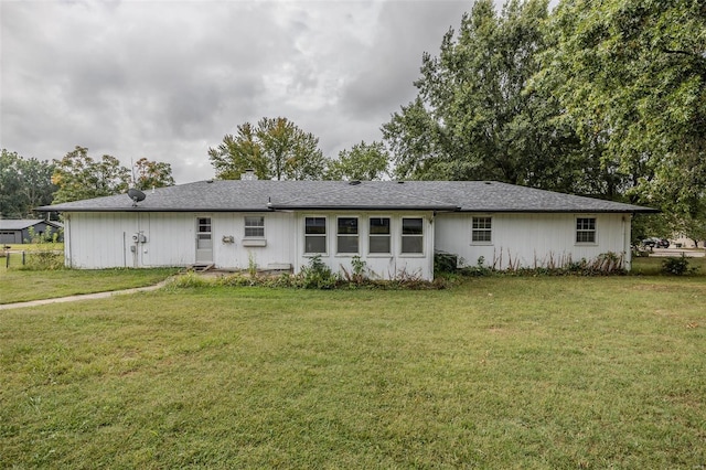 rear view of house featuring a yard