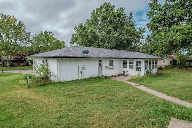 rear view of property with a yard and a sunroom