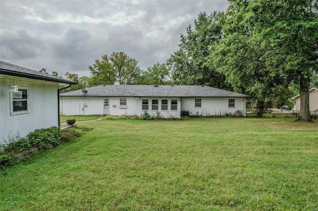 back of property featuring a lawn