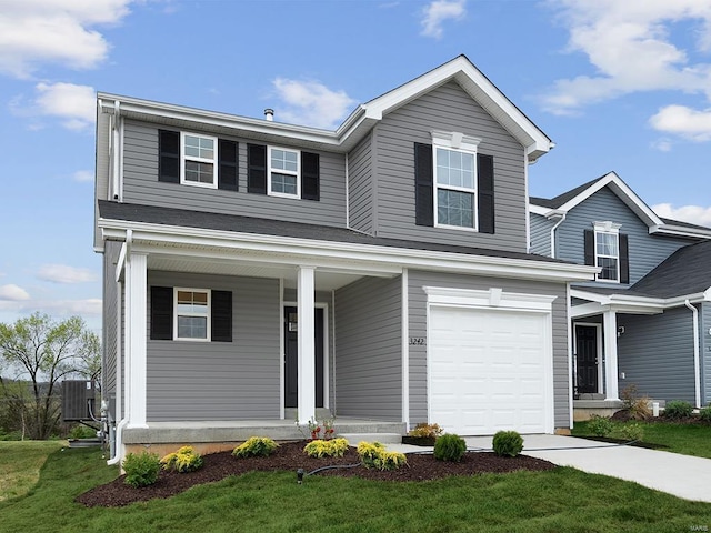 traditional-style house featuring an attached garage, central AC, concrete driveway, a front yard, and a porch