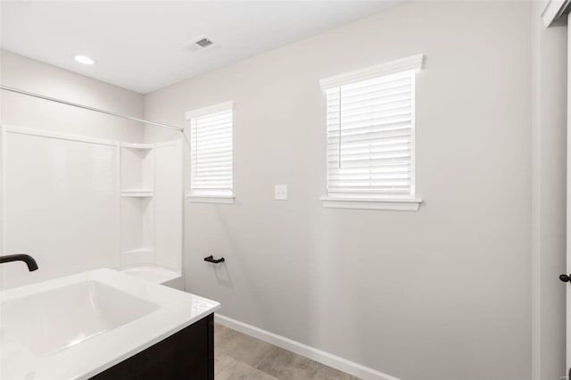 full bathroom featuring a shower, vanity, baseboards, and visible vents