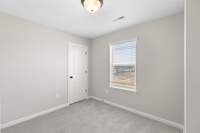 spare room with baseboards, visible vents, and light colored carpet