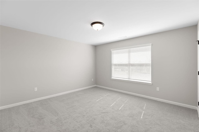 empty room featuring baseboards and carpet flooring