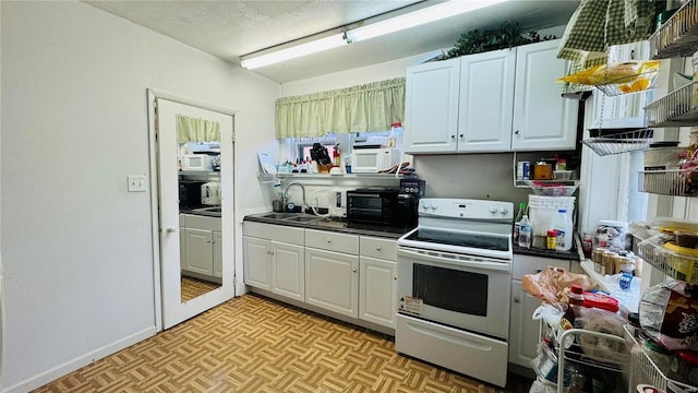 kitchen with light parquet floors, white appliances, and white cabinetry