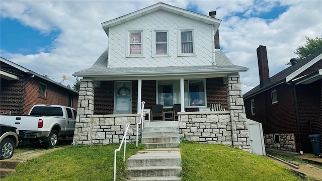 view of front of home featuring a front yard and covered porch