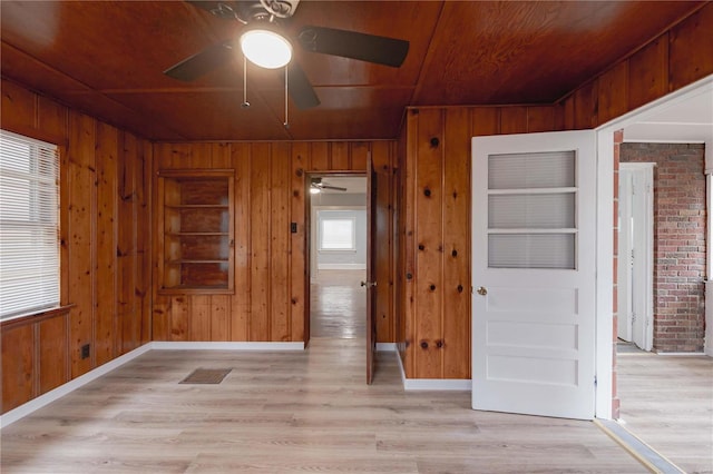 unfurnished bedroom featuring light wood-type flooring and wood walls