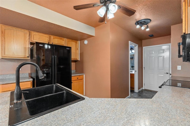 kitchen featuring ceiling fan, sink, a textured ceiling, black refrigerator with ice dispenser, and light brown cabinetry