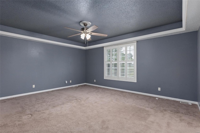 unfurnished room featuring ceiling fan, a textured ceiling, a tray ceiling, and carpet floors