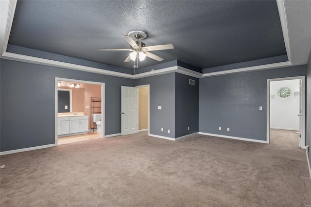 carpeted spare room with a textured ceiling, a raised ceiling, and ceiling fan